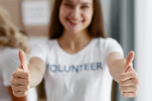 front-view-defocused-female-volunteer-giving-thumbs-up